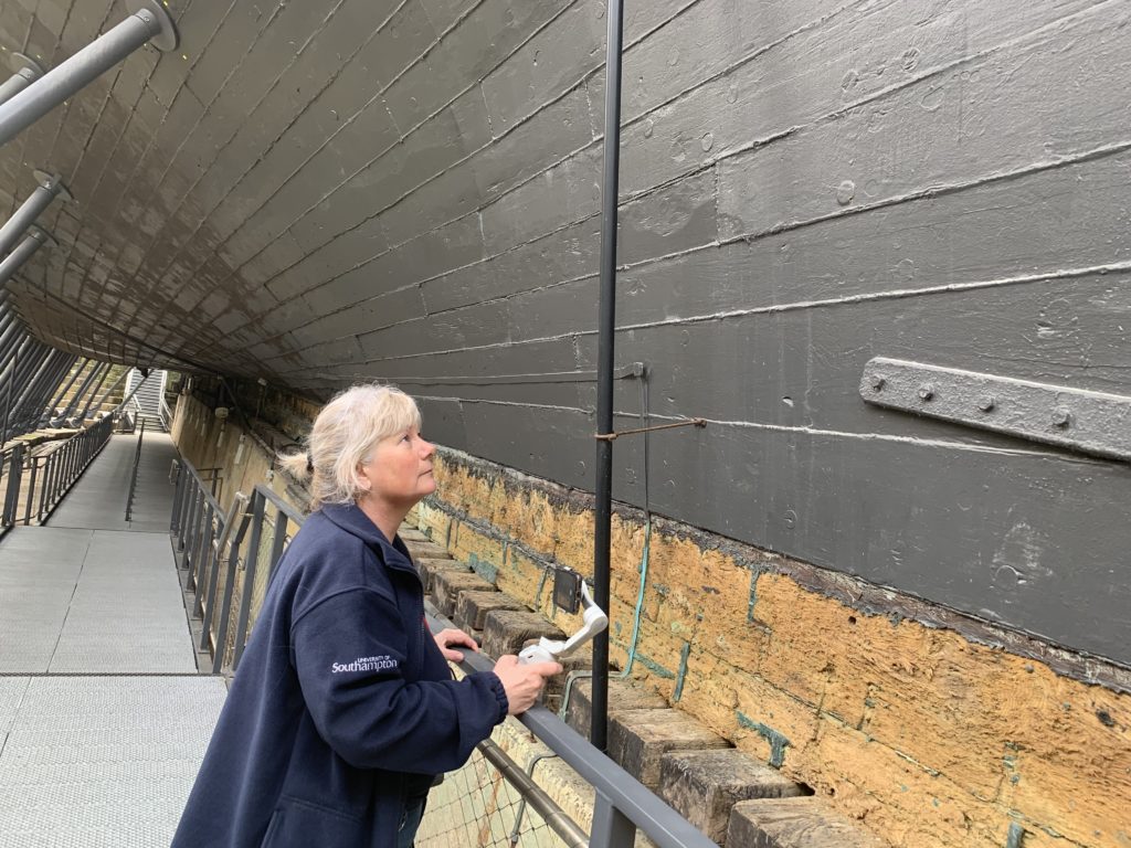 Sam Hambrook examining the paint under the ship