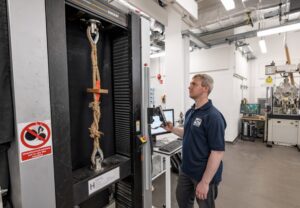 Dr Benjamin Cunningham conducting tensile tests in the lab - a section of rope with ladder fixings is being pulled in a machine