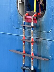Photo of a pilot ladder affixed to an opening in the side of a ship
